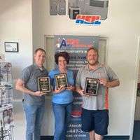 Three Atec Air & Heating team members holding industry recognition plaques